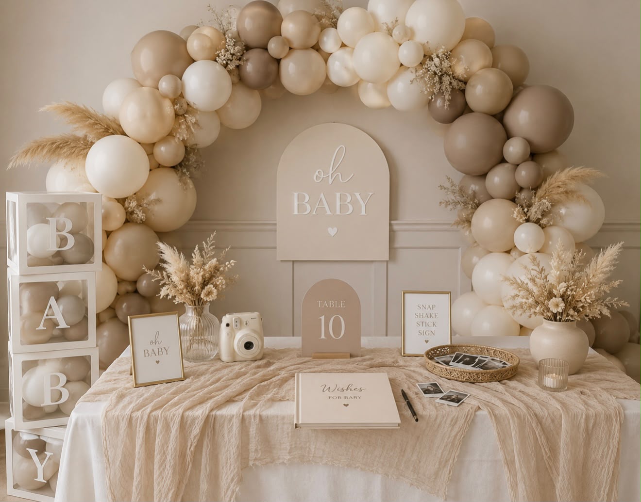 Soft beige baby shower table with balloon garland and welcome decor